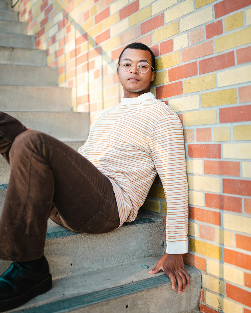 a young man sitting on the steps of a building