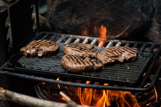 hamburgers and hamburger patties cooking on a grill