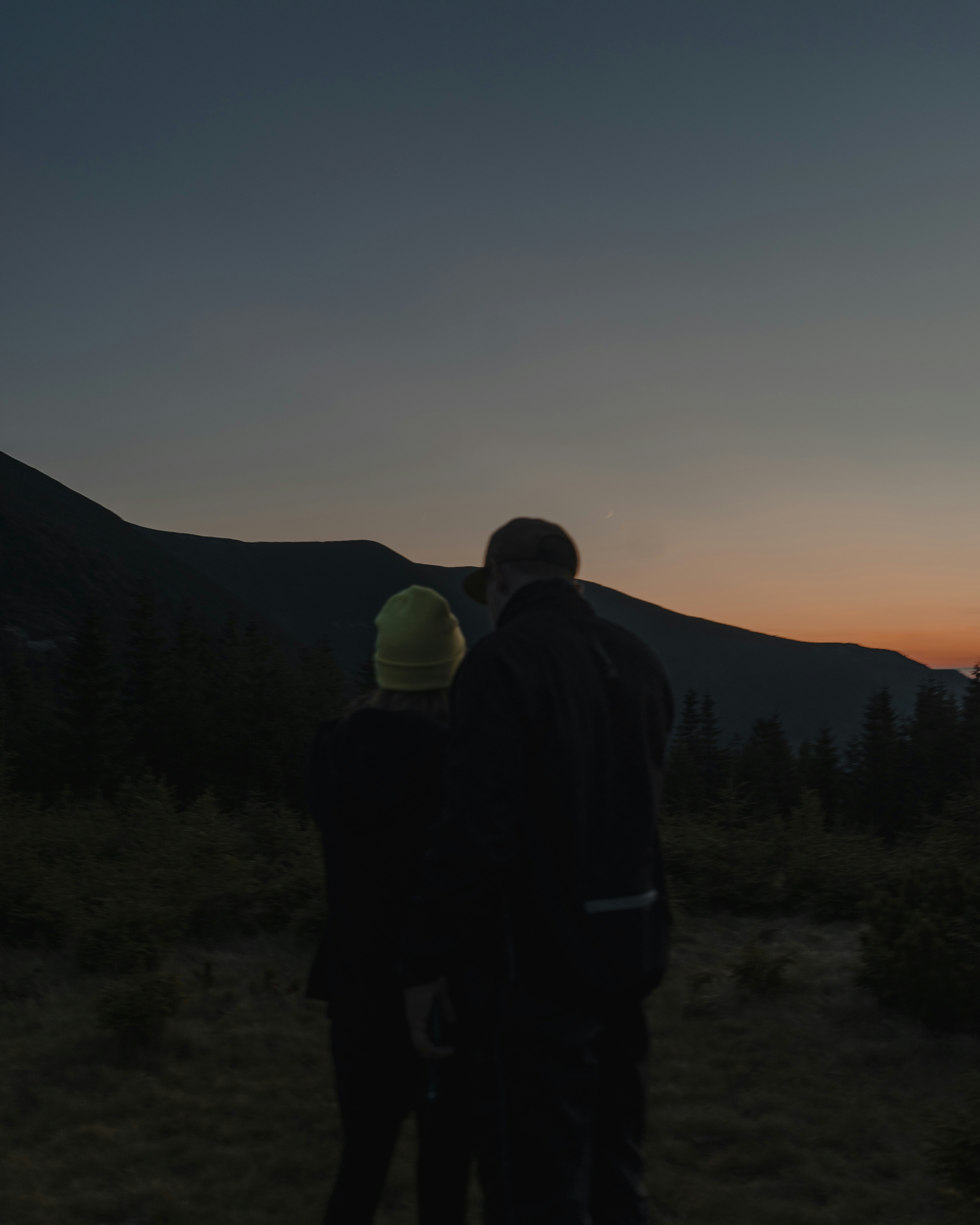a couple of people standing on top of a grass covered field