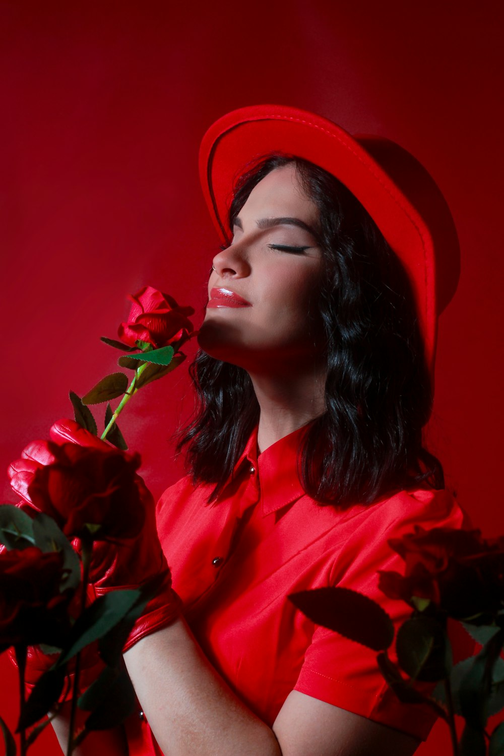 赤い帽子をかぶってバラを持つ女性
