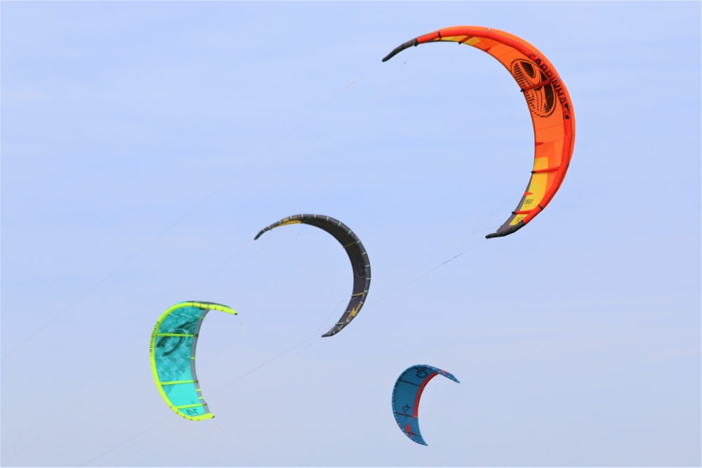 a group of people flying kites in the sky