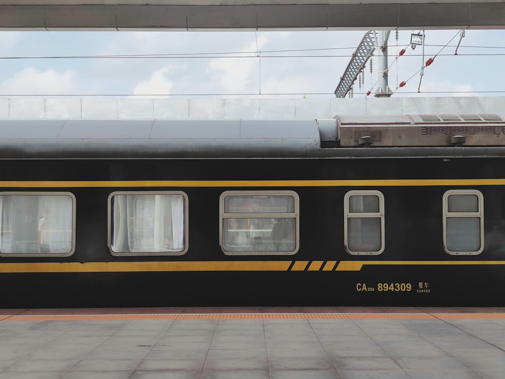 a black and yellow train is parked at a station