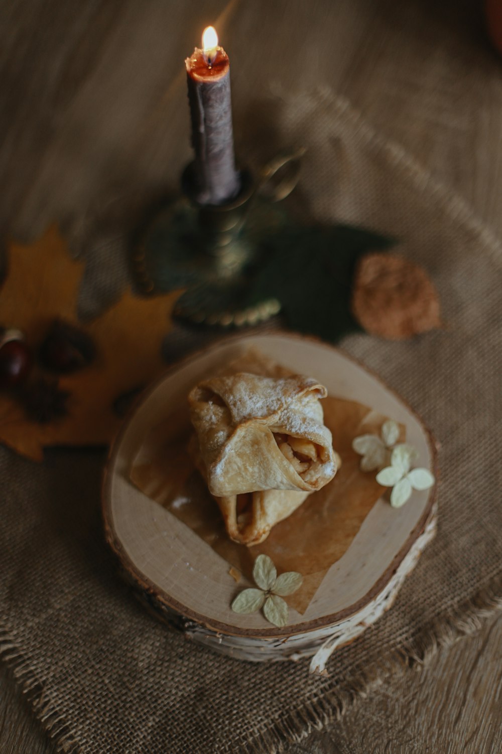 a small piece of food on a plate with a candle