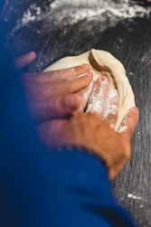 a person is kneading dough on a table