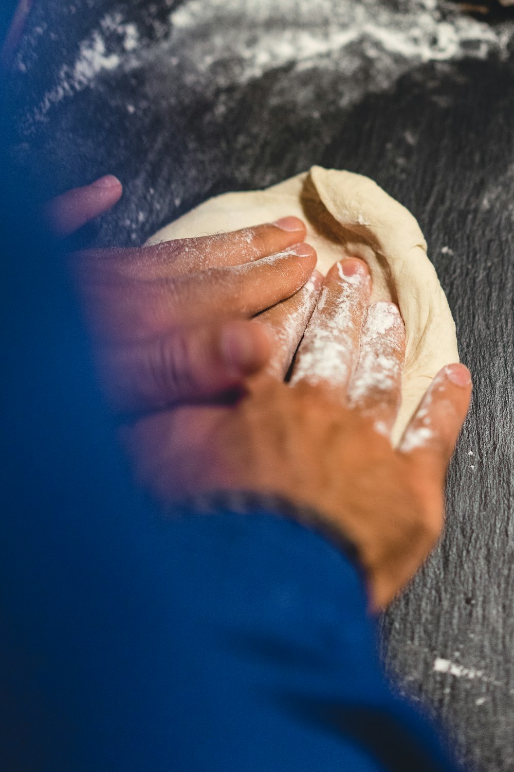 une personne pétrit de la pâte sur une table