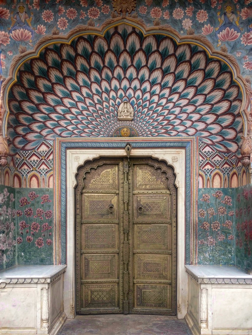 an ornate doorway with a bench in front of it