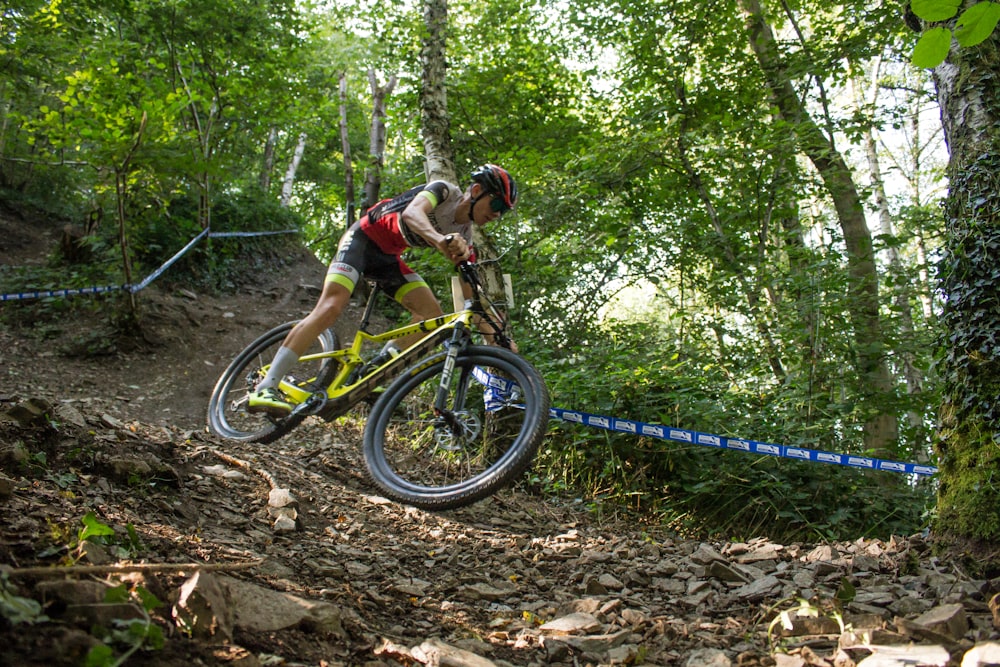 a person riding a bike on a trail in the woods