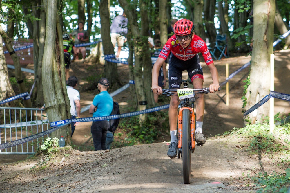 a man riding a bike down a dirt road