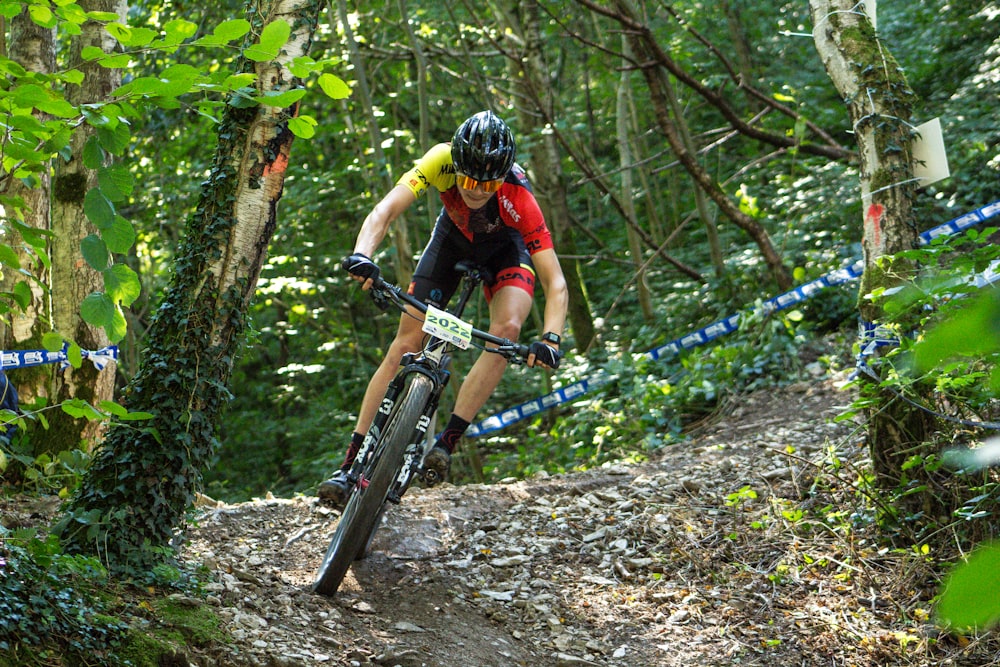 a person riding a bike on a trail in the woods