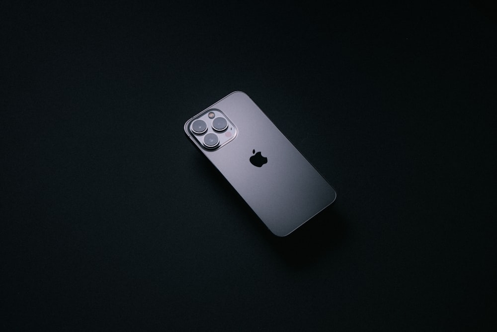 a silver cell phone sitting on top of a black table