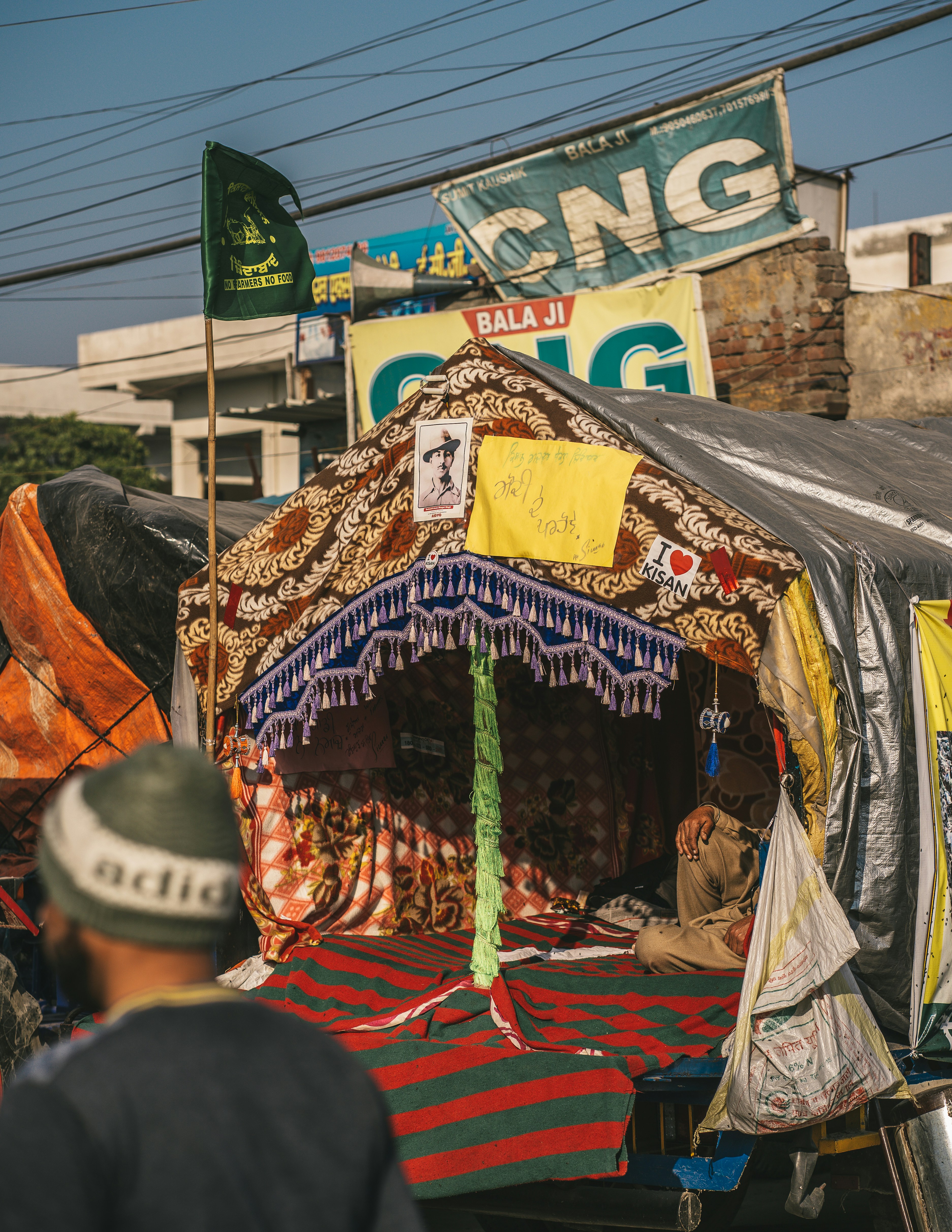 a man standing next to a tent in the street