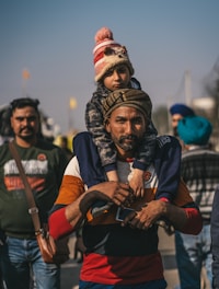 a man carrying a child on his shoulders