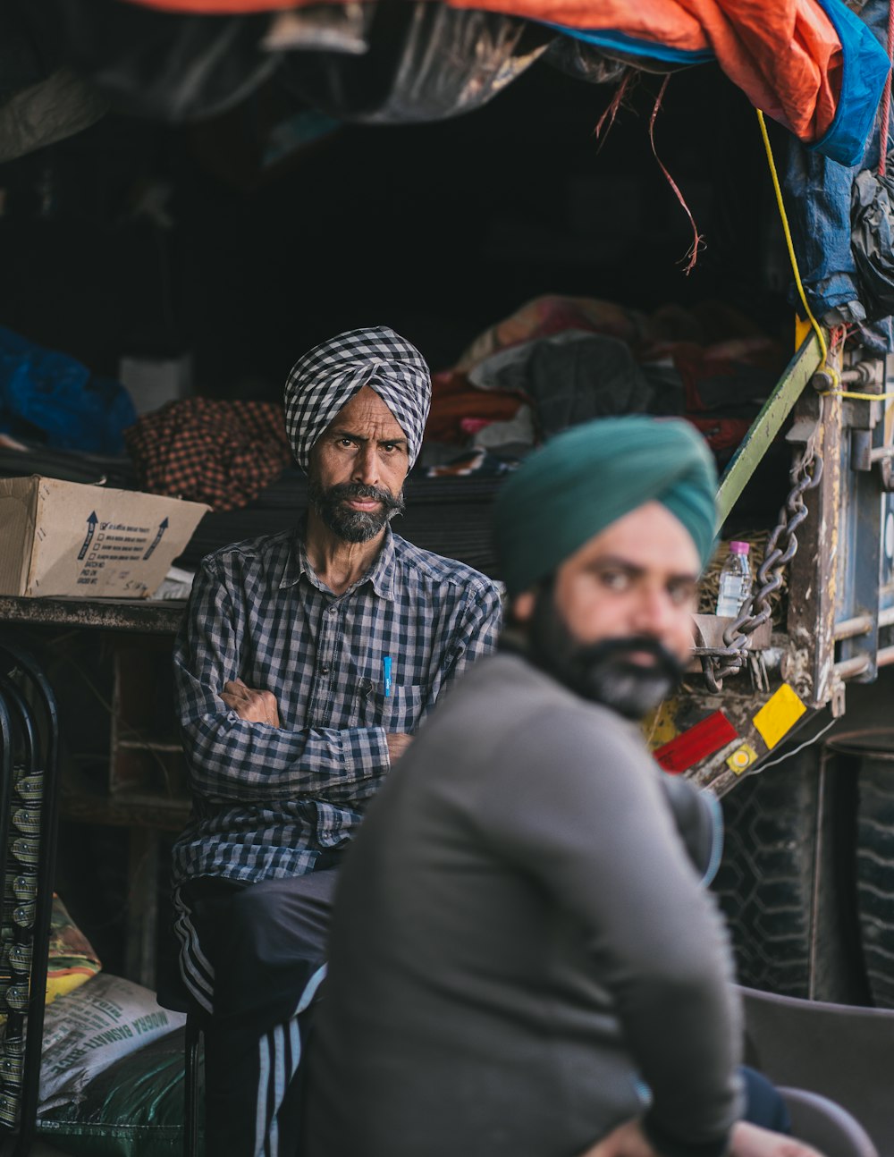 a man with a turban sitting next to another man