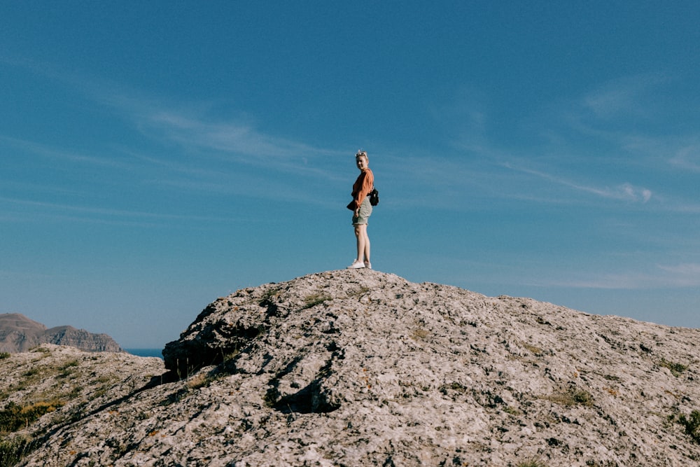 a person standing on top of a large rock