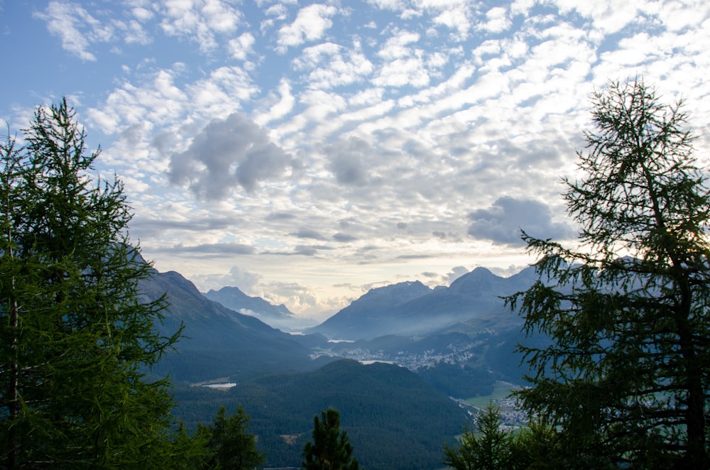 a view of a mountain range with trees and mountains in the background