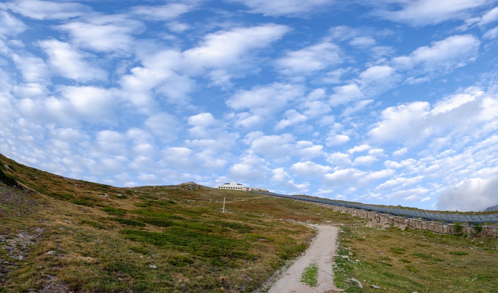 a dirt path going up a grassy hill