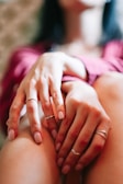 Close-up of hands gently resting on knees during a calming vagus nerve relaxation exercise.