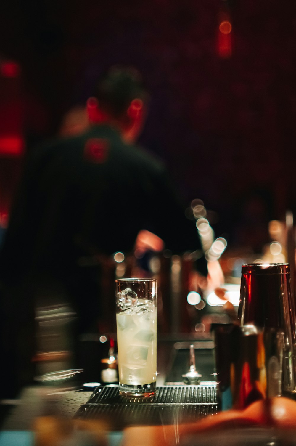 a person sitting at a bar with a drink in front of them