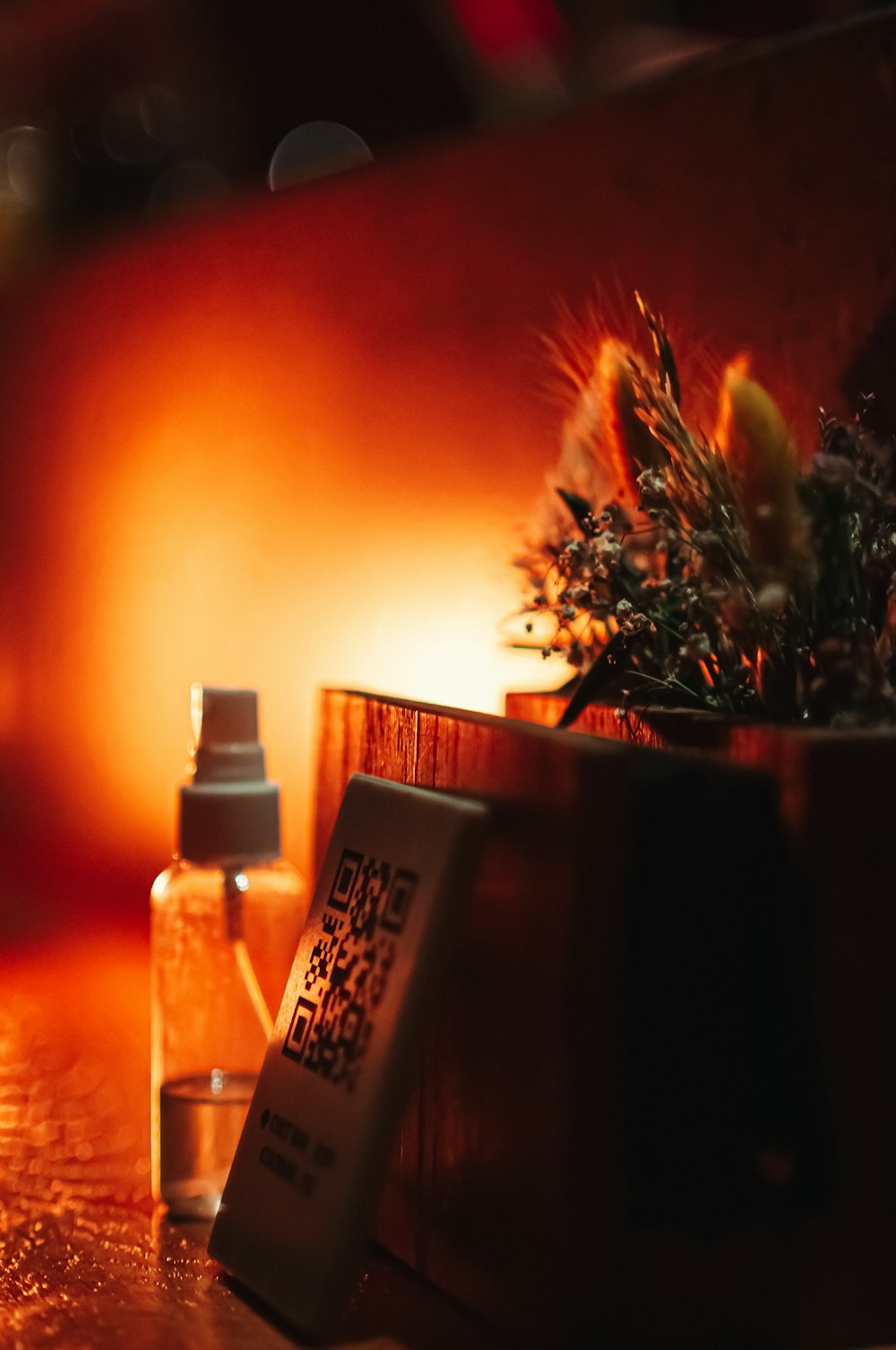 a close up of a bottle and a plant on a table