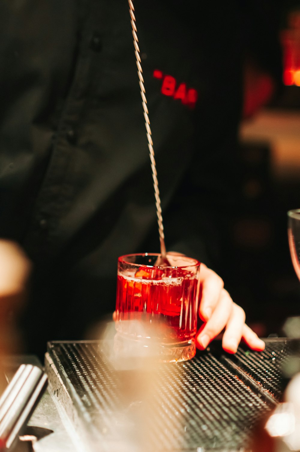 a person holding a glass of red liquid