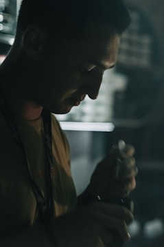 A hand holding improvised self-defense tools in a dimly lit room.