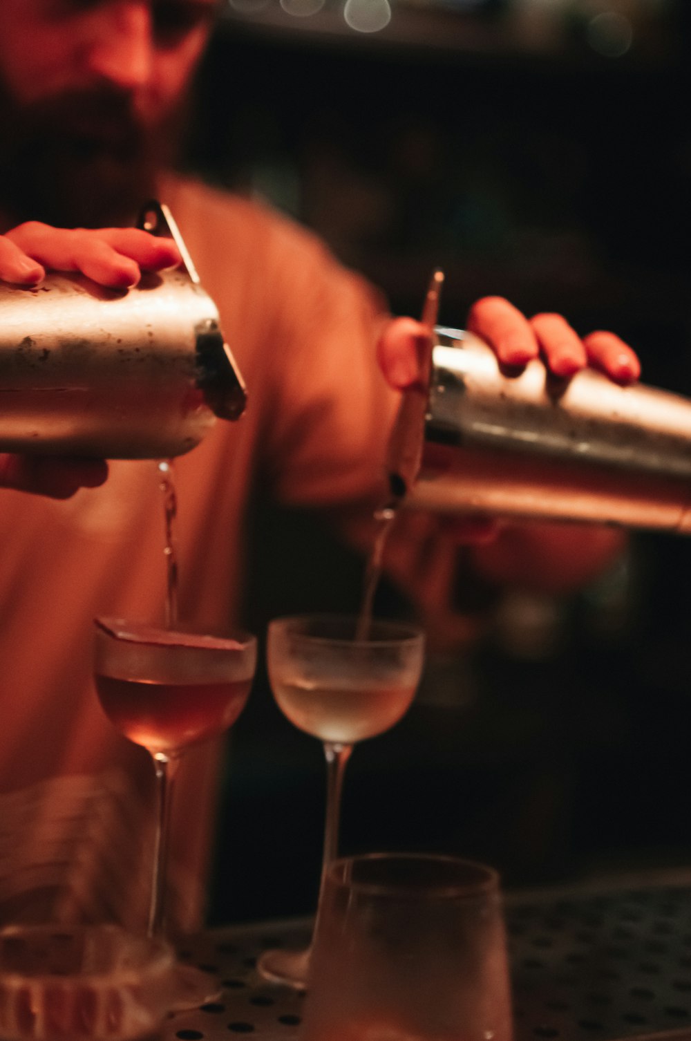 a bartender pouring a drink into a glass