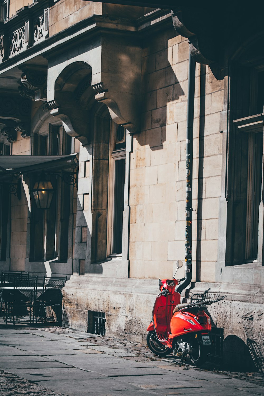 a red scooter parked in front of a building