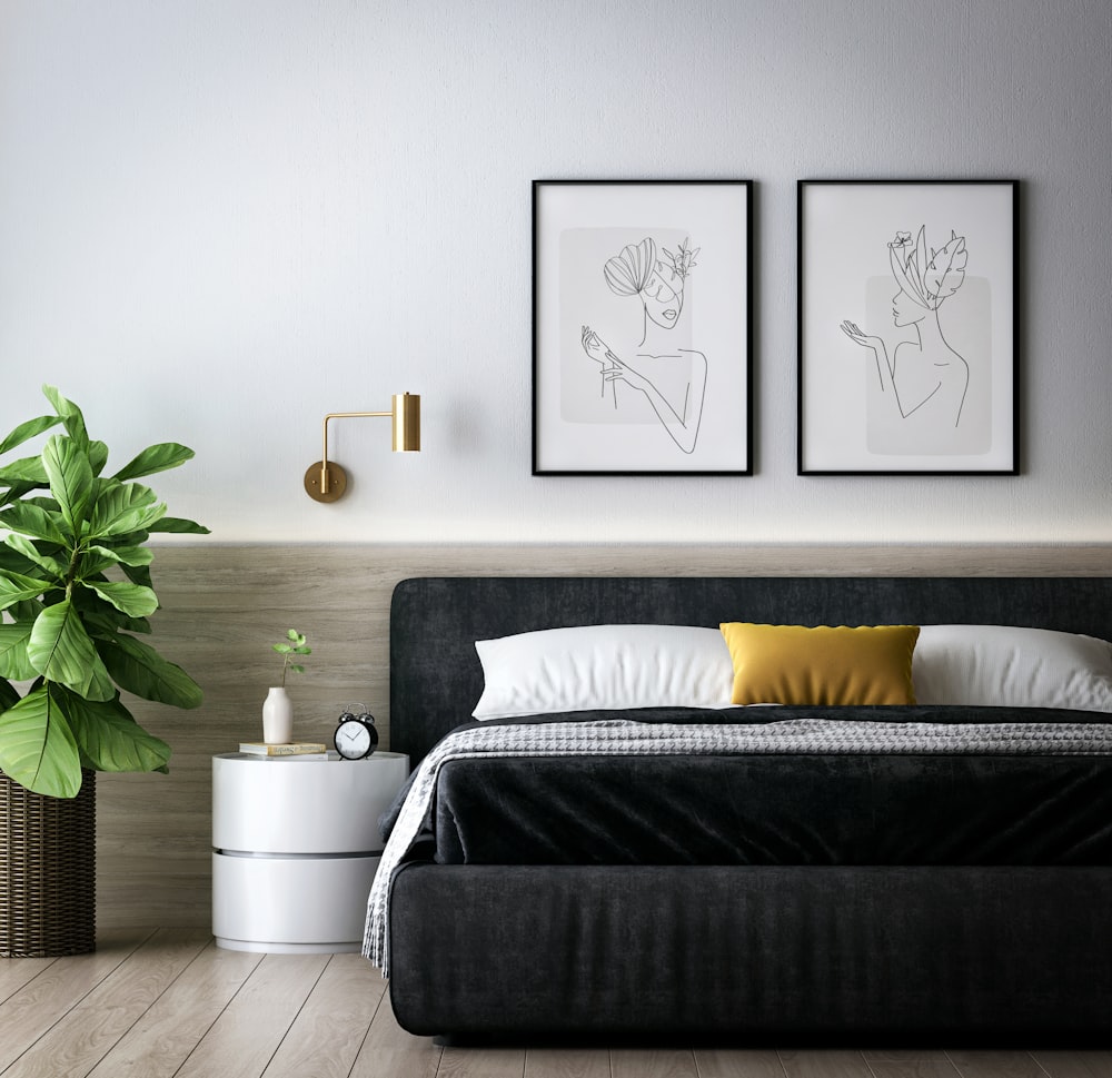 a bedroom with a bed and a plant in the corner