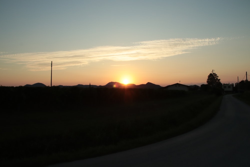 the sun is setting over the mountains in the distance