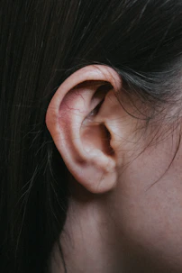 A detailed close-up of an ear examination showing the eardrum illuminated by an otoscope.