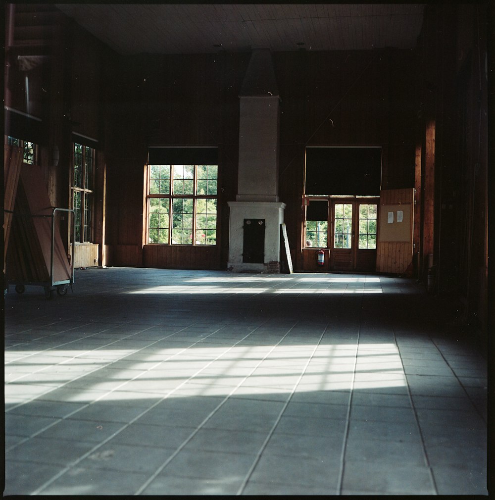 an empty room with a fireplace and windows