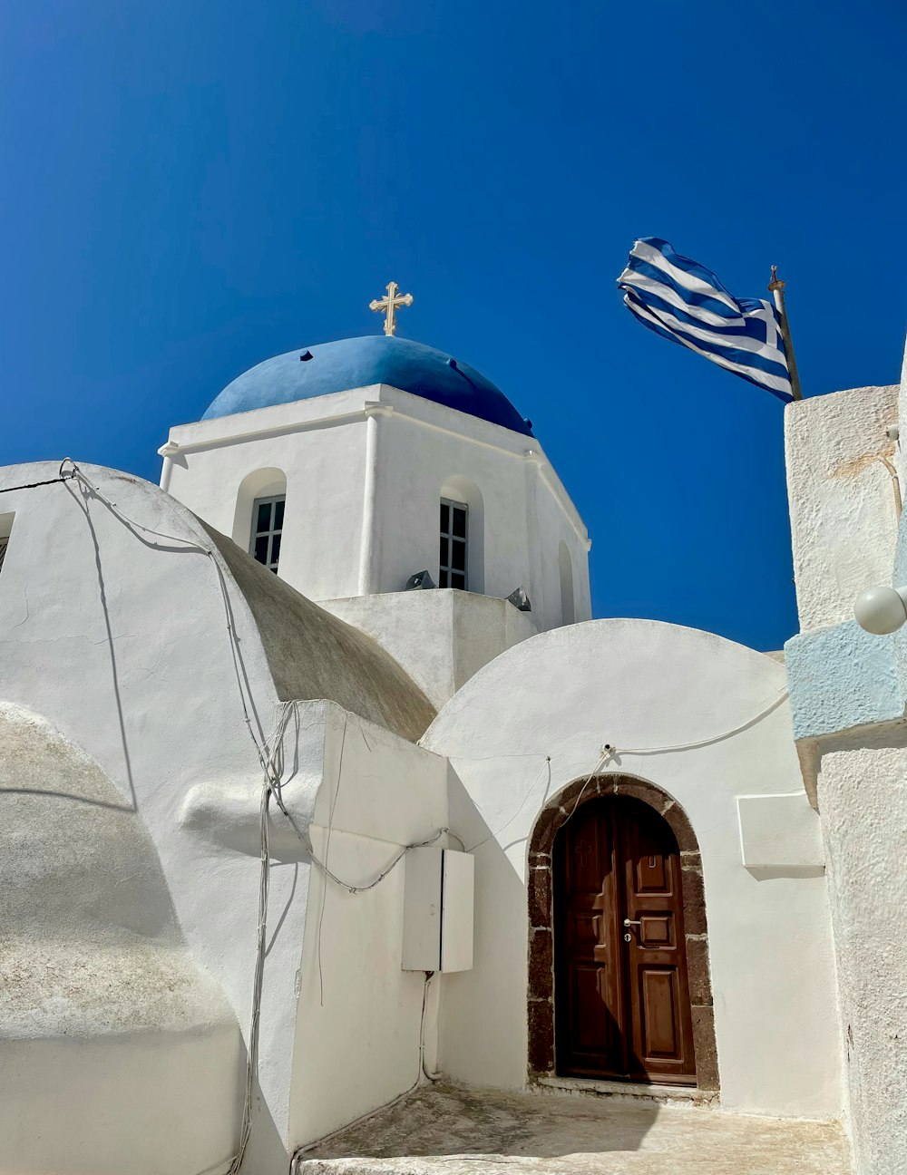 a white building with a blue dome and a cross on top