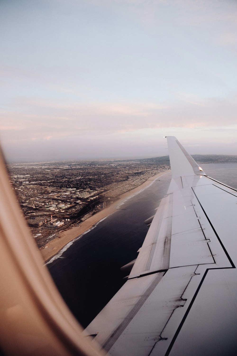 the wing of an airplane flying over a city