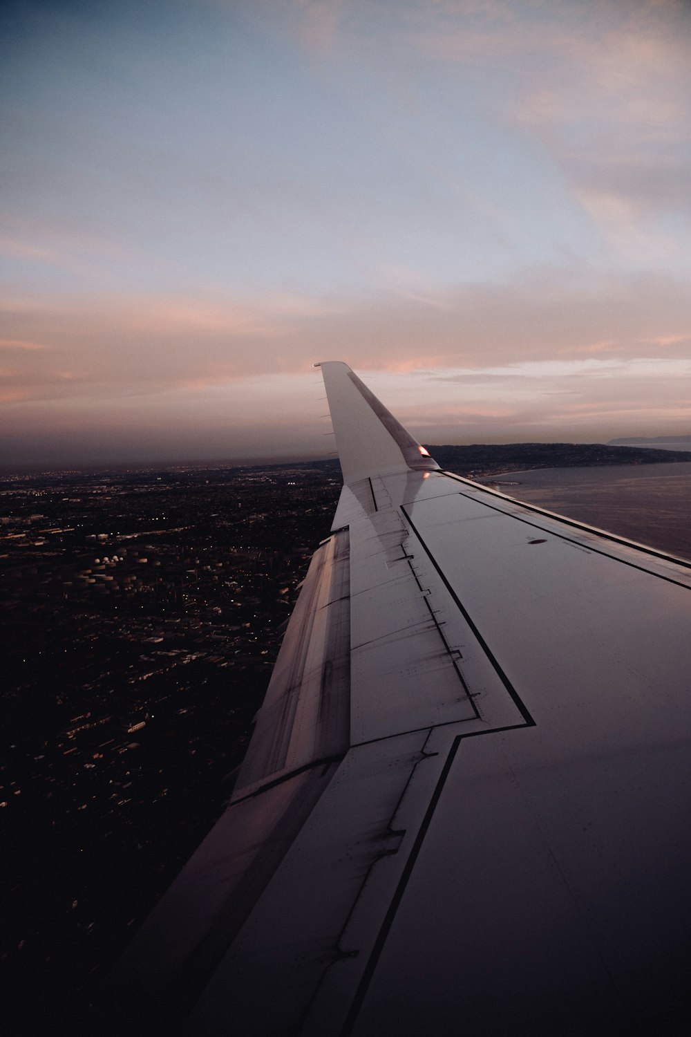 the wing of an airplane flying over a city