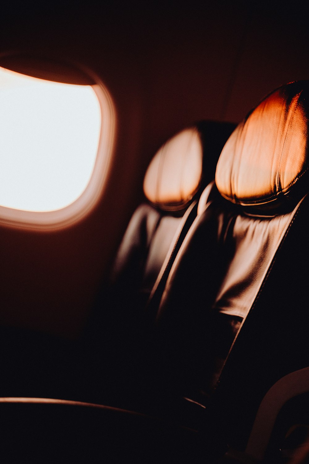 a seat in an airplane with the light coming through the window