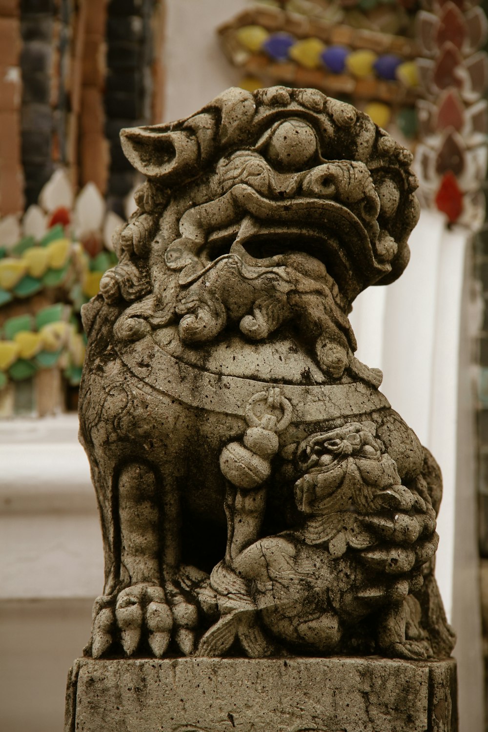 a stone statue of a lion on a pedestal