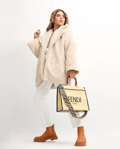 a woman in a fur coat holding a fendi bag