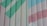 A metal surface with diagonal green and pink stripes painted over ribbed panels. The paint is slightly worn, giving a rustic appearance.