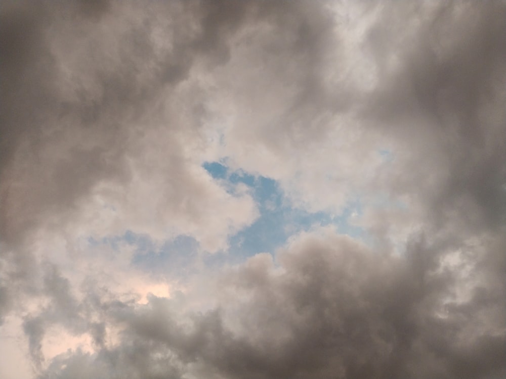 a plane flying through a cloudy sky on a cloudy day