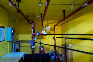 a room with yellow walls and red pipes