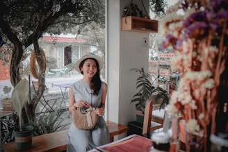 A joyful woman accessorizing her outfit with bagtati's signature pieces in a cozy café.