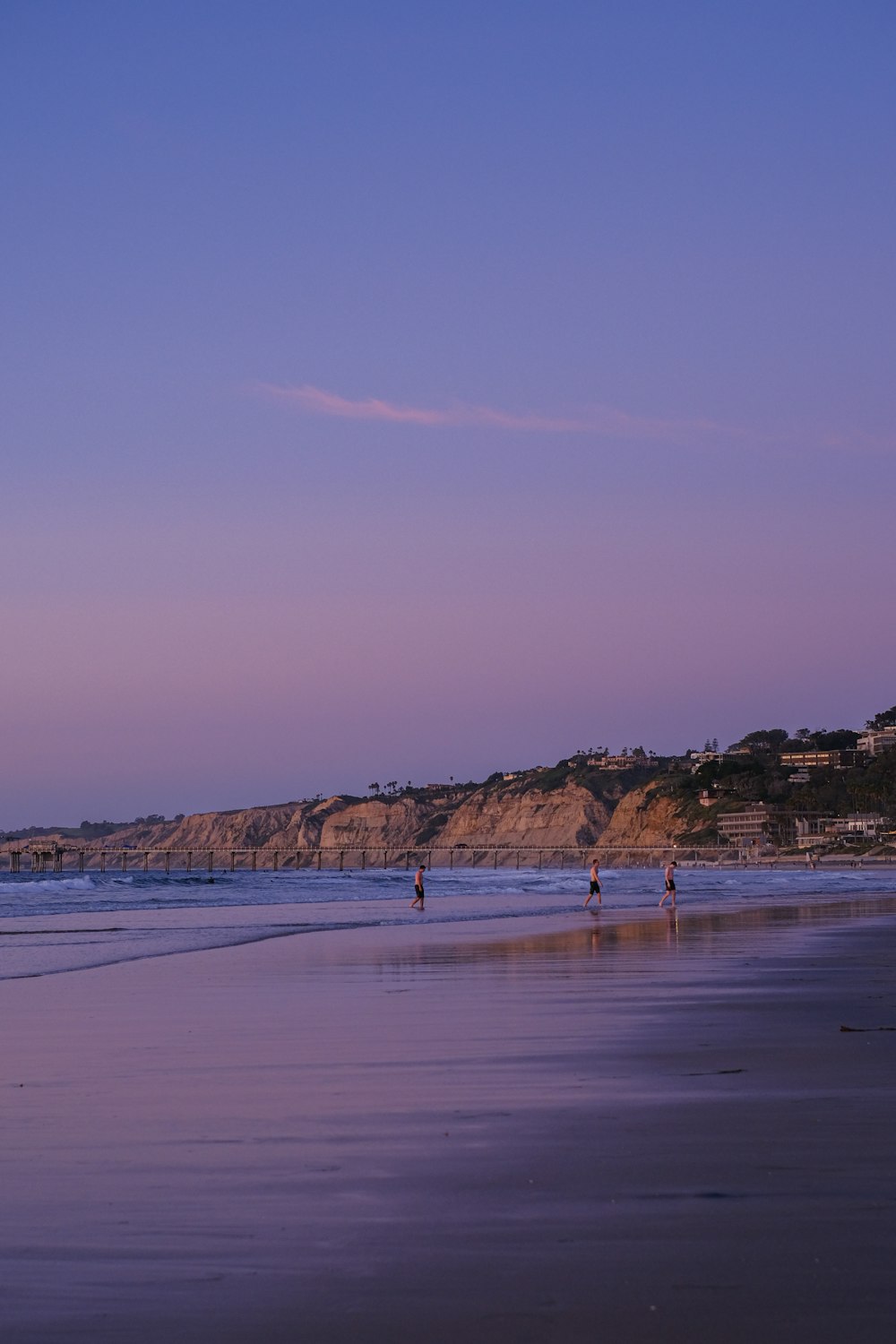 a couple of people standing on top of a beach