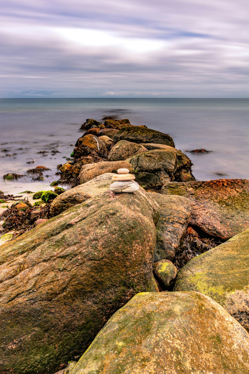 a pile of rocks sitting on top of a beach