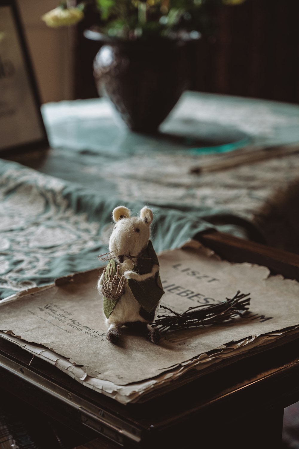 a teddy bear sitting on top of a book on a table