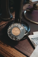 an old fashioned phone sitting on top of a wooden table