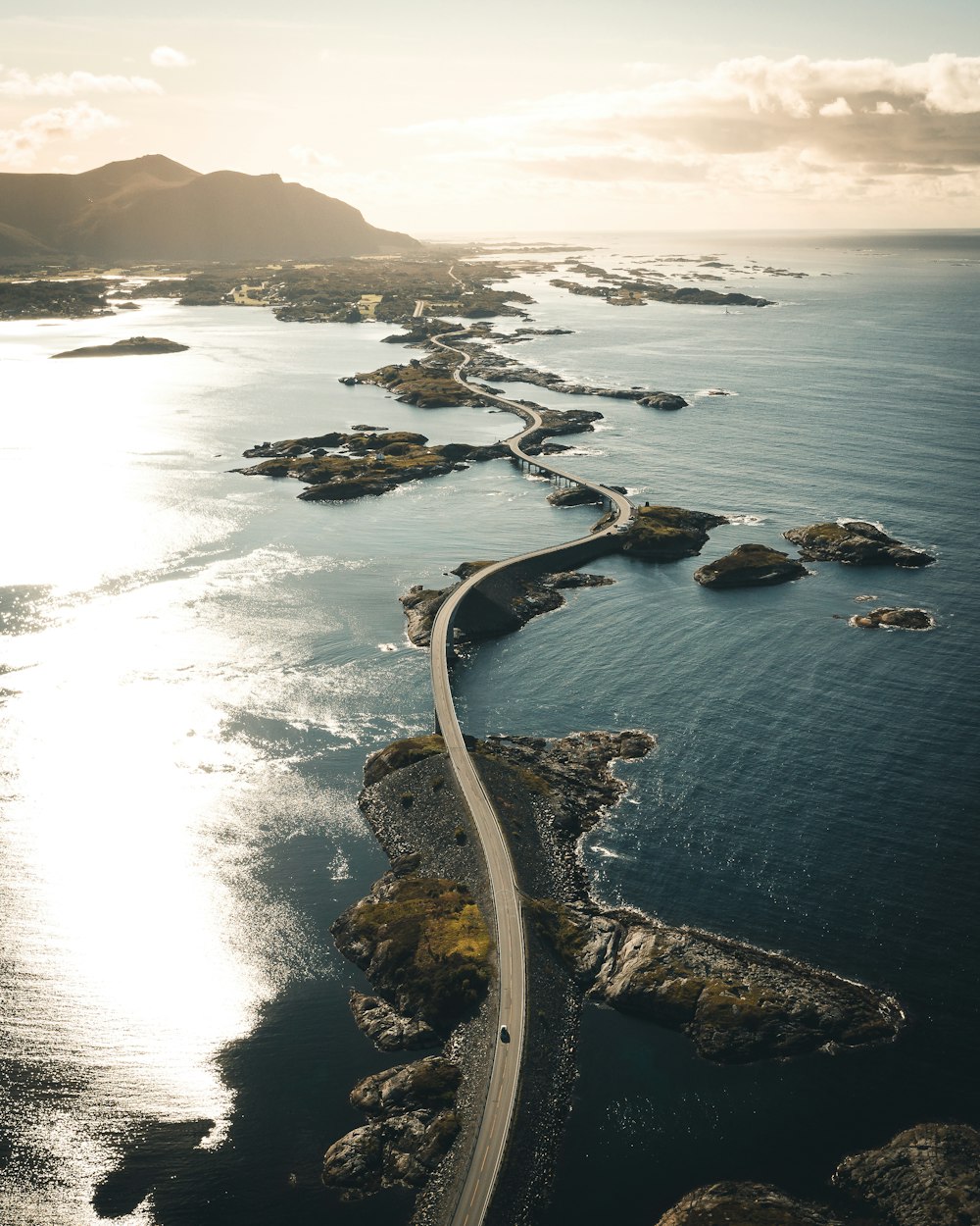 an aerial view of a road running through the ocean