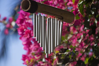 a metal wind chime hanging from a tree