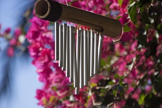 a metal wind chime hanging from a tree