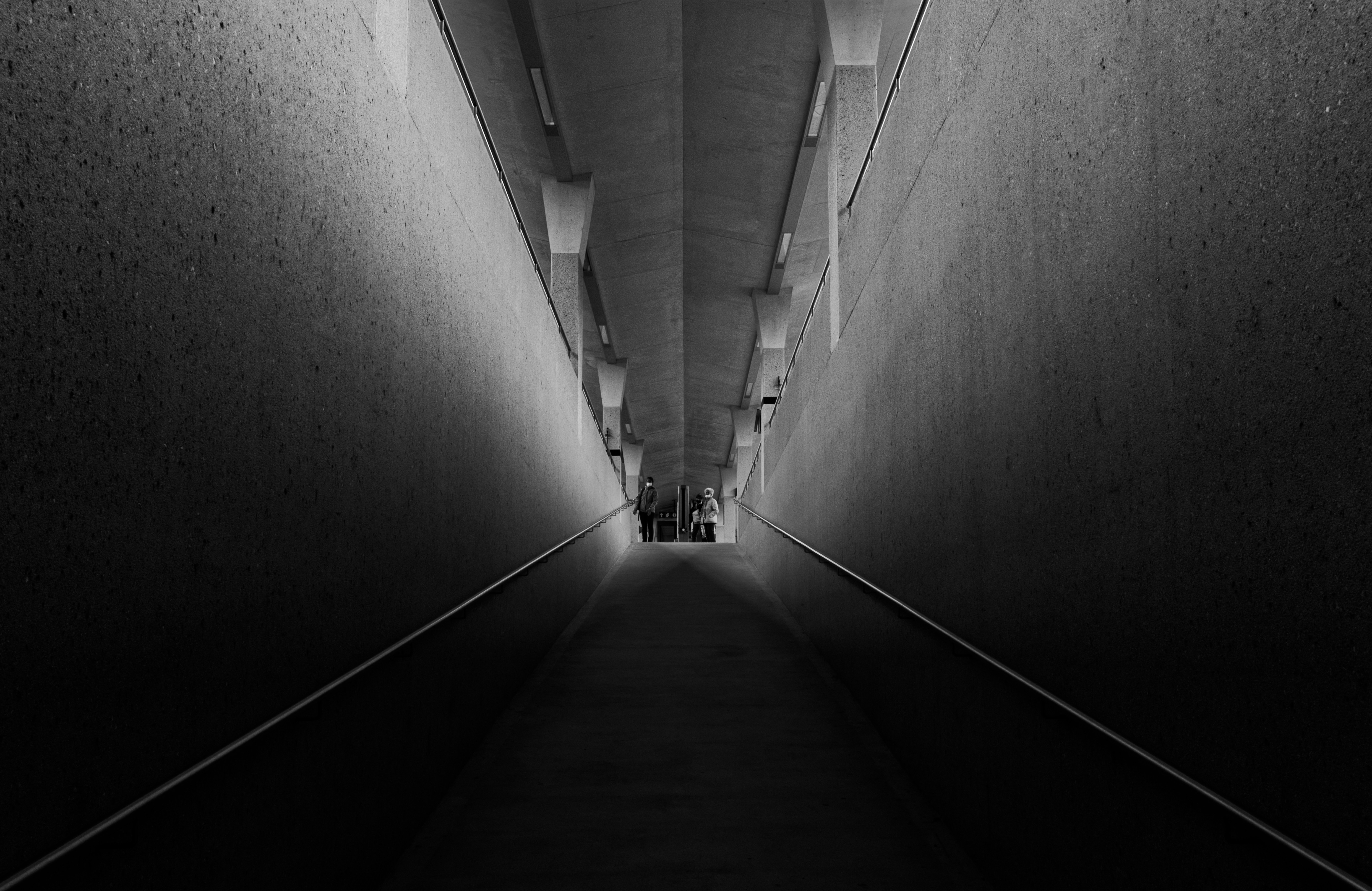 a long narrow tunnel with people walking down it