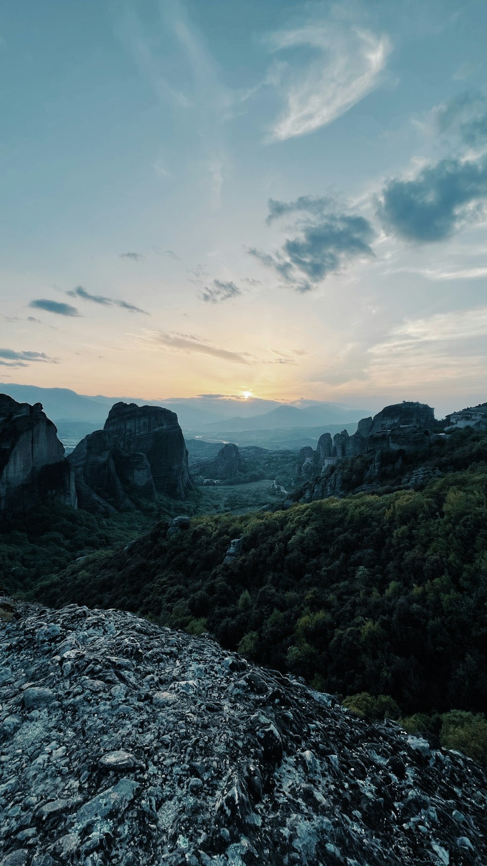 the sun is setting over the mountains in the distance